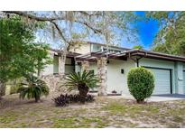 Charming single-story home featuring a stone facade and a well-manicured lawn in a peaceful, sunny neighborhood at 12 Robyn Ln, Haines City, FL 33844
