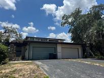 Exterior shot of home showcasing a multi car garage and a front yard at 12 Robyn Ln, Haines City, FL 33844