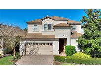 Charming two-story home with a tile roof, brick driveway and two-car garage at 1454 Myrtlewood St, Davenport, FL 33896