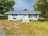 Charming single-story home with a metal roof, fresh paint and decorative shutters at 150 N Post Office Rd, Kenansville, FL 34739