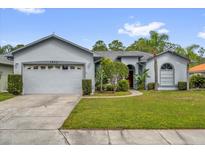 Charming single-story home with a well-maintained lawn, mature trees, and a two-car garage at 1532 Reade Cir, St Cloud, FL 34772
