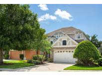 Charming two-story home with stone accents, landscaped yard, and a two-car garage at 1607 Tail Feather Dr, Kissimmee, FL 34746
