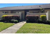 Inviting condo entrance with colorful bushes, walkway, and metal gate at 2246 Firestone Pl, Winter Haven, FL 33884