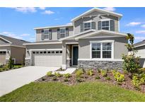 Charming two-story home featuring gray siding, stone accents, and a well-manicured front yard at 2943 Gavin Sky Dr, Kissimmee, FL 34744