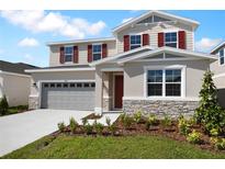 Inviting two-story home with a two-car garage, stone accents, and red shutters at 2961 Gavin Sky Dr, Kissimmee, FL 34744