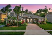 Beautiful single-Gathering home with a well-manicured lawn, mature landscaping, and a brick driveway at 3245 Heirloom Rose Pl, Oviedo, FL 32766