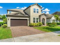 Charming two-story home featuring a brick driveway, attached two-car garage and a stone-accented entryway at 3447 Feathergrass Ct, Harmony, FL 34773