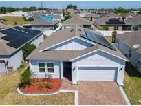 Beautiful one-story home with solar panels, brick driveway, manicured landscaping and attached two car garage at 372 Meadow Pointe Dr, Haines City, FL 33844