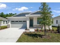 Charming single-Gathering home with a gray garage door and stone accents at 4076 Bannock Ave, Tavares, FL 32778