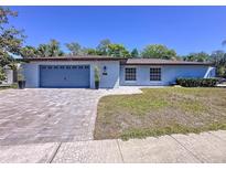 Charming one-story home featuring a blue exterior, paver driveway, and well-manicured lawn at 600 Swallow Dr, Casselberry, FL 32707