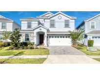 Charming two-story home with a well-manicured lawn, a paved driveway, and a two-car garage at 9036 Stinger E Dr, Davenport, FL 33896