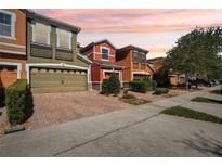 Colorful townhomes featuring brick driveways and well-maintained landscaping at 9535 Silver Buttonwood St, Orlando, FL 32832