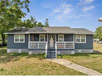 Charming single-story home featuring a lovely front porch with white railings and a well-maintained lawn at 1226 Pine St, Orlando, FL 32824