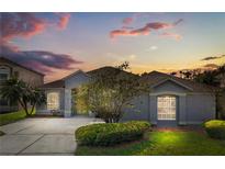 Charming single-story home boasts professional landscaping and a serene sunset sky, offering suburban curb appeal at 13115 Fox Glove St, Winter Garden, FL 34787