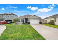 Charming single-story home with a well-maintained lawn and a two-car garage at 194 Henry Steven Dr, Haines City, FL 33844