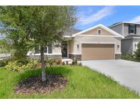 Inviting single-story home boasts a well-manicured lawn and a neutral color palette at 306 Alexandrite St, Deland, FL 32720