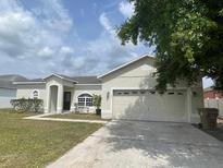 Charming single-story home with well-maintained lawn, two car garage, and beautiful landscaping at 322 Ashburton Way, Kissimmee, FL 34758