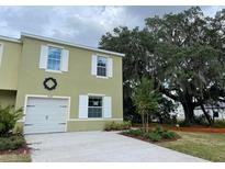 Two-story home with attached garage, white trim, manicured landscaping, and stunning mature tree at 4247 Shackelford Ct, Orlando, FL 32824