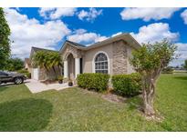 Charming home featuring a stone accent facade, well-manicured lawn, and lush landscaping at 4910 Culdesac Ct St, St Cloud, FL 34772