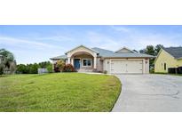 Charming single-story home with a well-manicured lawn, two-car garage, and a welcoming front porch at 5524 Loma Vista, Davenport, FL 33896