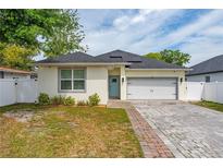 Charming single-Gathering home with a well-manicured front lawn and a brick paver driveway at 7629 Marietta St, Orlando, FL 32807