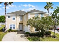 Charming two-story home with a well-manicured lawn and beautiful landscaping at 814 Bloomingdale Dr, Davenport, FL 33897