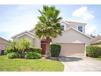 Charming single-Gathering home featuring a well-manicured lawn and mature palm trees in a residential neighborhood at 423 Corvina Dr, Davenport, FL 33897