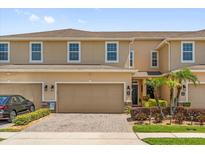 Inviting two-story townhome featuring a two-car garage and well-maintained landscaping at 1031 Wood Cv, Kissimmee, FL 34743