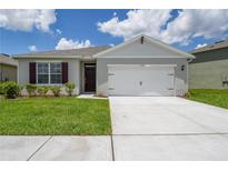 Charming single-story home featuring a two-car garage, well-maintained lawn, and traditional architectural details at 2705 Grandbury Grove Rd, Lakeland, FL 33811