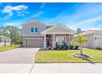 Charming two-story home with a manicured lawn, paved driveway, and neutral-toned facade, plus a two-car garage at 3038 Camden Way, Davenport, FL 33837