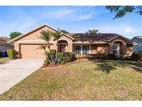Charming single-story home with a well-manicured lawn, front garden, and attached two-car garage at 4216 Gold Rush Ln, St Cloud, FL 34772