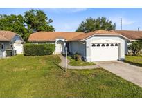 Charming single story home with a well maintained lawn, a garage, and mature landscaping at 907 Robinson Ave, St Cloud, FL 34769