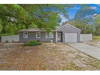 Charming gray home featuring a single-car garage and lovely curb appeal at 9513 Bahia Rd, Ocala, FL 34472