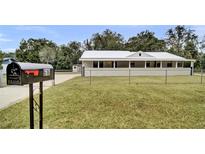 Inviting single-story home featuring a large, charming front porch and well-maintained lawn with a metal roof at 616 Se 31St Ter, Ocala, FL 34471