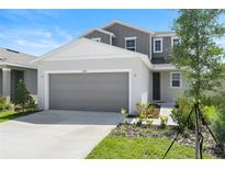Charming two-story home featuring a gray exterior, well-maintained lawn and a two car garage at 6393 Clover St, Lake Hamilton, FL 33851