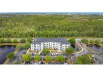 Apartment complex with lush greenery, parking, and lakeside views offers a serene living environment at 3176 Feltrim Pl # 202, Kissimmee, FL 34747