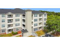 Three-story apartment building featuring balconies and manicured landscaping in a serene neighborhood at 3176 Feltrim Pl # 202, Kissimmee, FL 34747