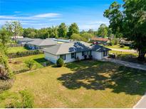Charming single Gathering home featuring a well-maintained lawn and backyard, set on a bright and sunny day at 1401 Nw 63Rd Pl, Ocala, FL 34475