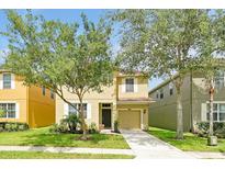Charming two-story home with well-maintained lawn and mature landscaping at 8904 Candy Palm Rd, Kissimmee, FL 34747