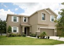 Two-story home with a well-manicured lawn and a two-car garage, exuding curb appeal and modern comfort at 1039 Tourmaline Dr, Kissimmee, FL 34746