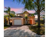 Charming two-story home with a brick driveway, attached garage, and well-maintained landscaping at 1119 Mariner Cay Dr, Haines City, FL 33844