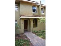 Charming two-story townhouse with a welcoming brick walkway, arched entry, and well-maintained landscaping at 1122 Spaceport Ct, Kissimmee, FL 34741