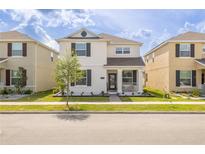 Charming two-story home featuring black shutters, a porch, and a well-manicured front yard at 11456 Rhyme Ave, Orlando, FL 32832