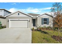 Charming one-story home features a gray stucco exterior, two-car garage, and simple, attractive landscaping at 1741 Carnelian St, Deland, FL 32720