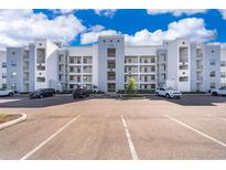 Apartment building showcasing a modern design with white and gray accents against a bright blue sky at 3120 Paradox Cir # 302, Kissimmee, FL 34746