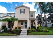 Inviting two-story home with well-manicured landscaping and an American flag, presenting a charming curb appeal at 5101 Staniard Dr, Kissimmee, FL 34746