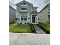 Charming two-story home with a well-manicured lawn, tidy landscaping, and a welcoming walkway at 11312 Listening Dr, Orlando, FL 32832