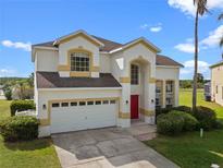 Charming two-story home featuring a red door, neutral stucco exterior, and an attached two car garage at 107 Troon Cir, Davenport, FL 33897