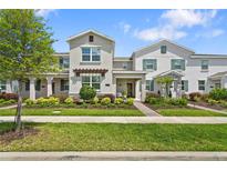 Charming two-story townhome with well-maintained landscaping and inviting front porch at 11473 Listening Dr, Orlando, FL 32832