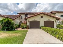 Charming townhome with a well-manicured lawn, mature landscaping, and a two-car garage at 117 Coventry Ln, Haines City, FL 33844